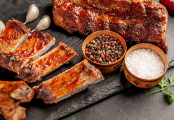  grilled pork ribs with spices on a stone background