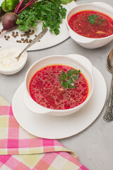 Borsch is a traditional Ukrainian soup. Two white ceramic cups with vegetable soup.