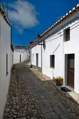 Fototapeta na wymiar Typical narrow street lined with white houses, Serpa city, Alentejo, Portugal