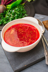 Borsch is a traditional Ukrainian soup. Vegetable soup with sour cream in a ceramic cup on an old wooden surface.