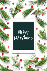 Christmas composition on a white background. Merry Christmas-handwritten inscription on the gadget screen. Flat lay.