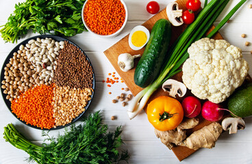 Healthy wholesome vegetarian diet food. Plate with raw chickpeas beans and lentils on a light...