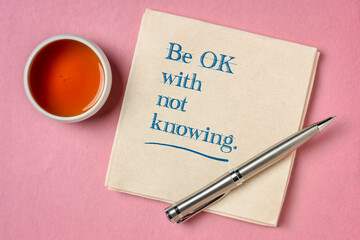 be OK with not knowing inspirational advice - handwriting on napkin with a cup of tea, unknown uncertainty and stress concept