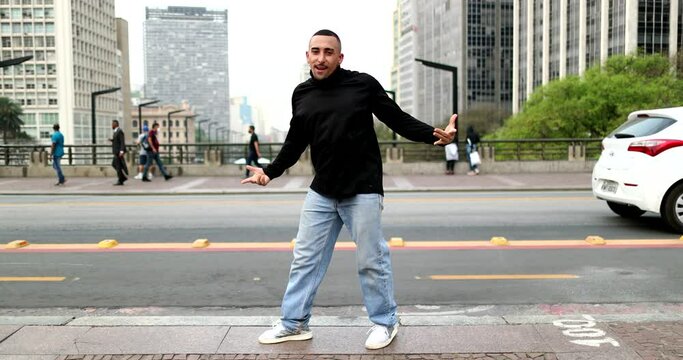 Happy hispanic man dancing in downtown city in street