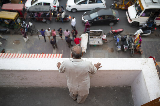 (Selective focus) A man of Indian ethnicity is watching from a balcony, the traffic on the streets of Jaipur during the Covid-19 outbreak. 