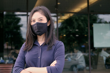 portrait of a woman with fabric mask, restaurant in background 
