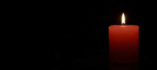 One red candle burning on a black banner background.Free space for text.