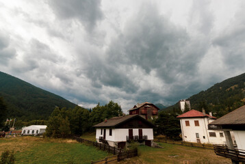 Fototapeta na wymiar Landscape Pragelato with mountain and white house, cloudy sky in winter