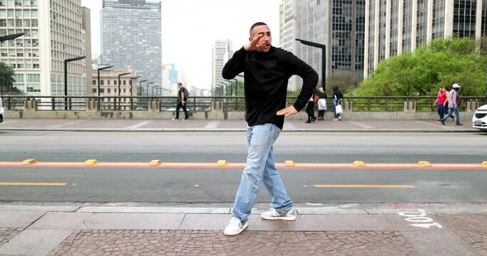 Happy hispanic man dancing in downtown city in street