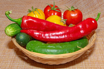Cucumbers tomatoes and peppers on the background