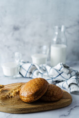 Rye bun in a plate with glasses of milk