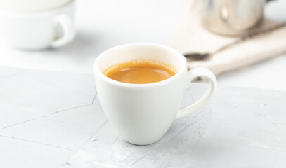 Small cup of hot espresso coffee on concrete background
