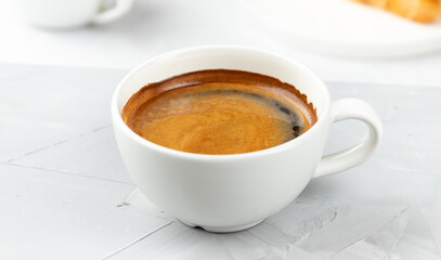 White cup of hot coffee americano on concrete background