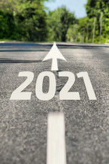 Road to 2021 year. Asphalt road with road markings and 2021 sign. Direction to the future 2021 year
