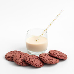 Cherry velvet cookies and glass of baked milk on white background.
