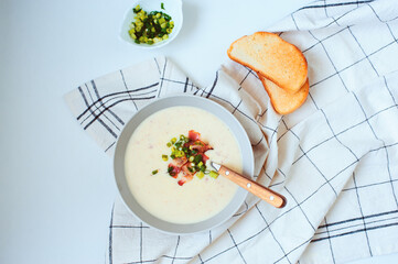 potato cream soup with bacon and green onion served in bowl on white background. Delicious food for...