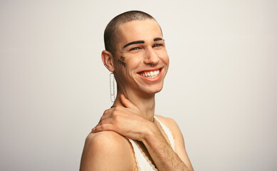 Gender fluid man smiling on white background