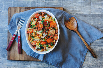 cooking tasty comfort food - italian fusilli pasta baked with meat sauce, cherry tomatoes and cheese