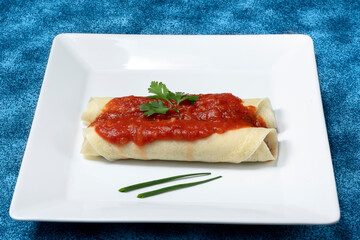 beef pancake with red sauce and parmesan cheese on a white plate	