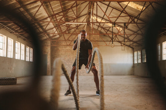 Strong Man Exercising With Battle Ropes