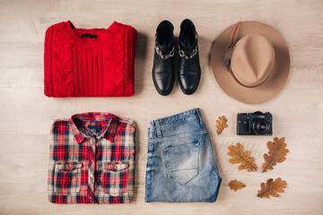 flat lay of woman style and accessories, red knitted sweater, checkered shirt, denim jeans, black leather boots, hat, autumn fashion trend, view from above, vintage photo camera, traveler outfit