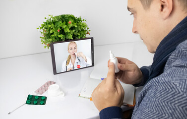 A man communicates via a tablet with a doctor via video link. Medical assistance under quarantine conditions. Remote consultation with a therapist