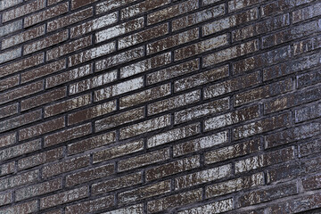 The black glossy brick wall of a modern apartment building. Modern nordic architecture. Pattern of brick wall.
