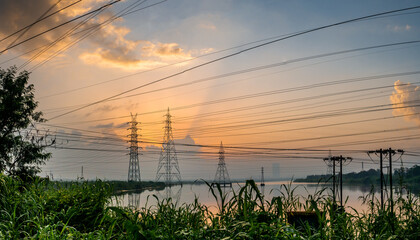 Obraz premium High-voltage power lines at Sunrise/sunset. .Saltpans in Mumbai.