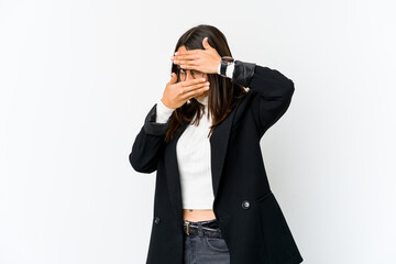 Young mixed race business woman isolated on white background blink at the camera through fingers, embarrassed covering face.