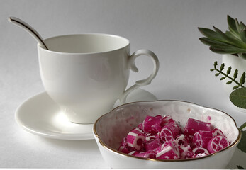 Obraz na płótnie Canvas Sweet fruit lollipops for tea on the table with a cup on a saucer 