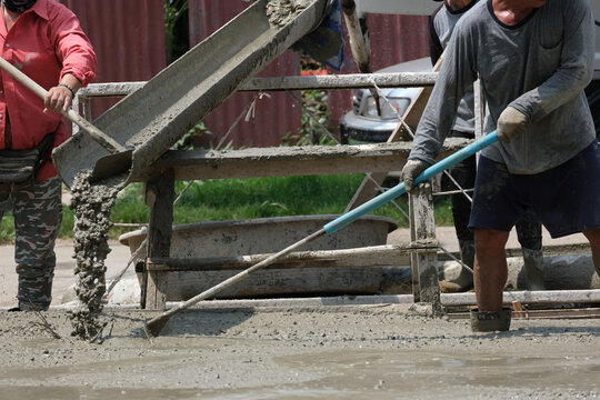 cement truck pour fluid concrete into floor house . Group of worker working mixer material in site.