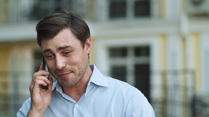 Portrait man having phone talk outdoor. Man talking on phone in shirt outdoor