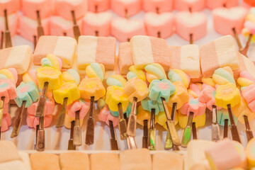 Naklejka premium Different colorful marshmallow on sticks. (Select focus)