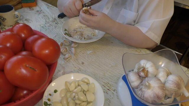 female chef peels garlic with a knife. healthy food concept