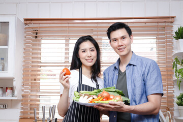 Asian couples cook together in their home kitchens. Living Concept During Covid-19, Social Distance, copy space