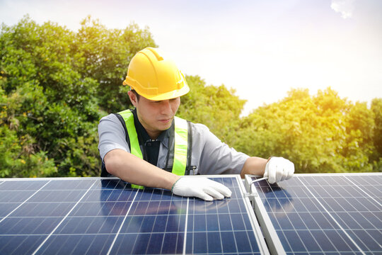 Asian Technicians Install Panels Solar Cells To Produce And Distribute Electricity. Energy Technology Concept