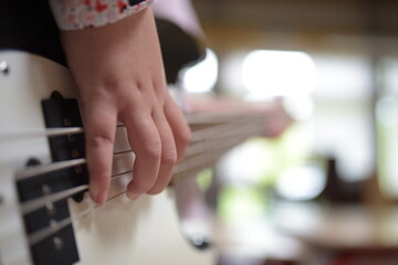 A child playing a white electric guitar