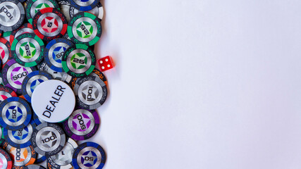 Pskov, Russia - 10.01.2020. Poker chips, dealer icon and dice  for casino game on a white background. Casino chips frame