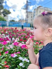 little girl smelling flowers