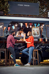 Hipster couple ordering from food truck; Urban lifestyle concept