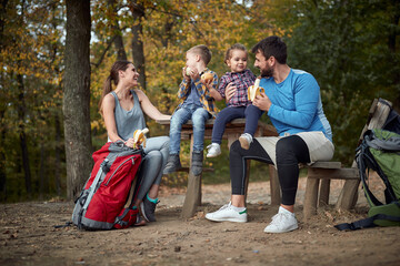 Happy family having a snack together; Spring or autumn hiking in nature; camping, travel,...