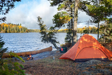 Campsite with orange tent on northern Minnesota lake during autumn © Daniel Thornberg