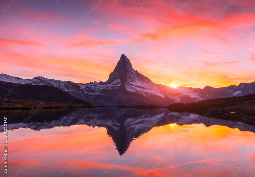 Wall mural picturesque landscape with colorful sunrise on stellisee lake. snowy matterhorn cervino peak with re