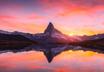 Picturesque landscape with colorful sunrise on Stellisee lake. Snowy Matterhorn Cervino peak with...