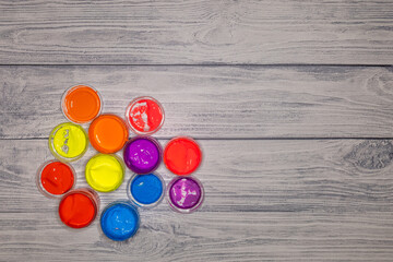 jars of paint on a wooden texture background