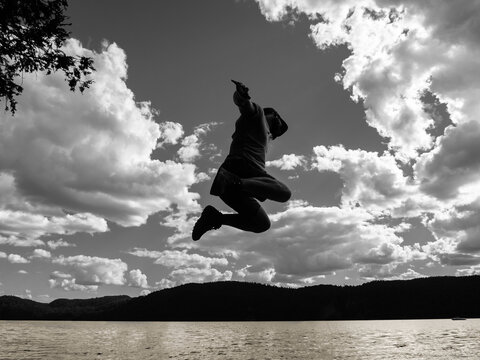Black and white photography of a young man jumping in the air