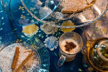 The tasty homemade cinnamon cake with sugar, accompanied by a cup of fresh coffee with chocolate and some Tasty and healthy almond cookies, rich in vitamins. copy space.
