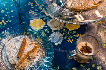 The tasty homemade cinnamon cake with sugar, accompanied by a cup of fresh coffee with chocolate and some Tasty and healthy almond cookies, rich in vitamins. copy space.