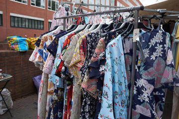 A rack of colourful patterns shirts in an outdoor market
