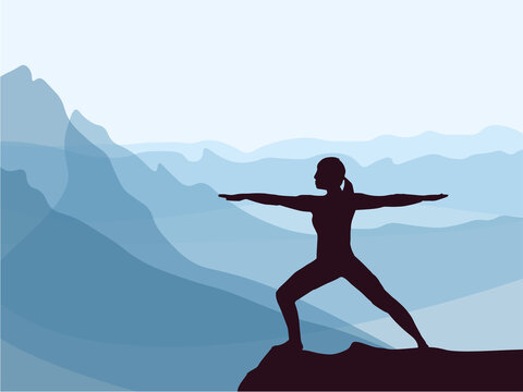 Silhouette of girl practicing yoga. Blue mountains in background. Healthy lifestyle.